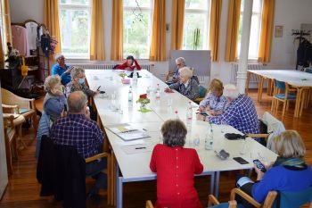 Ältere Menschen im Café-Treff am Smartphone